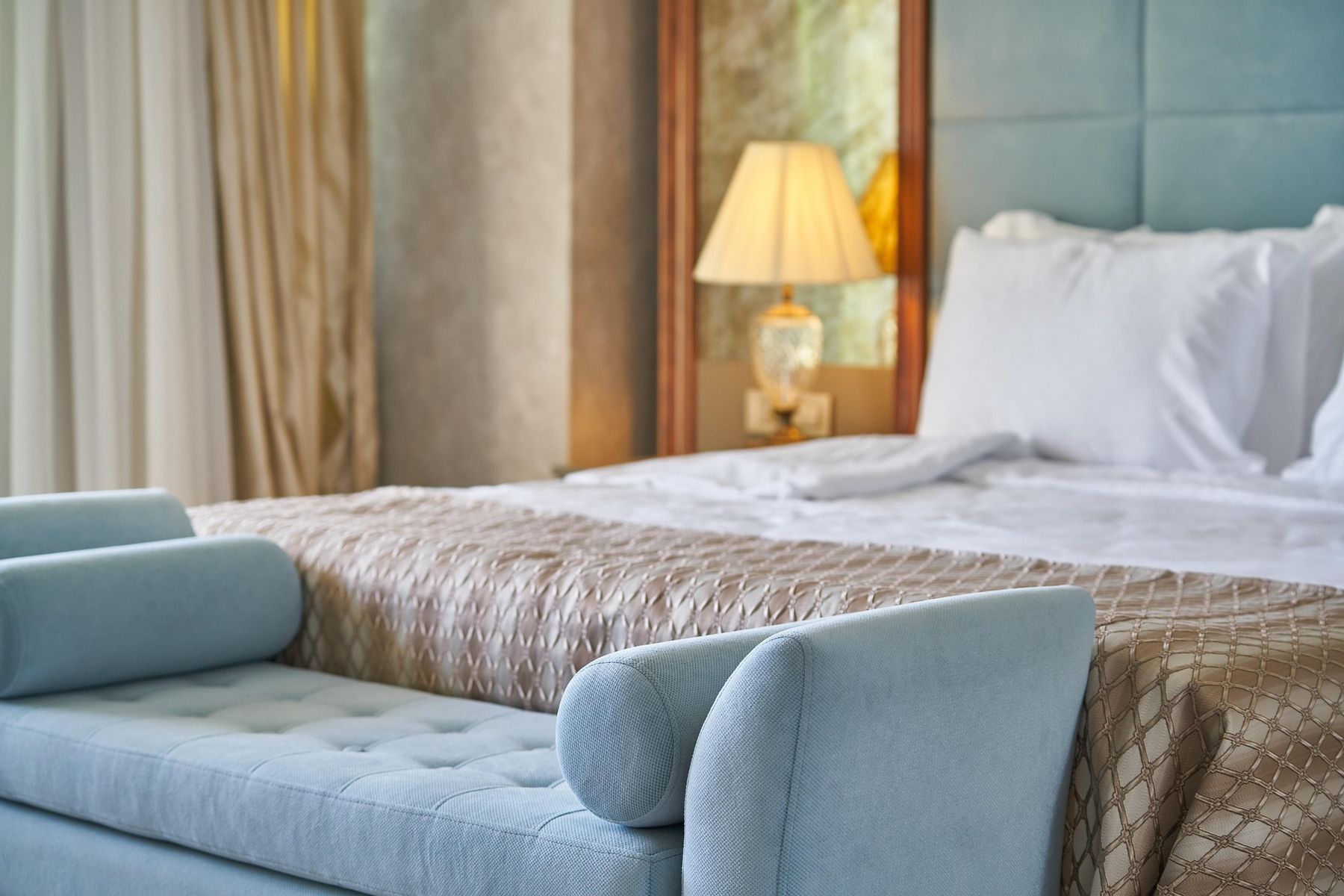 A furnished bedroom at Meadow River Lofts with a made bed and warm lamplight