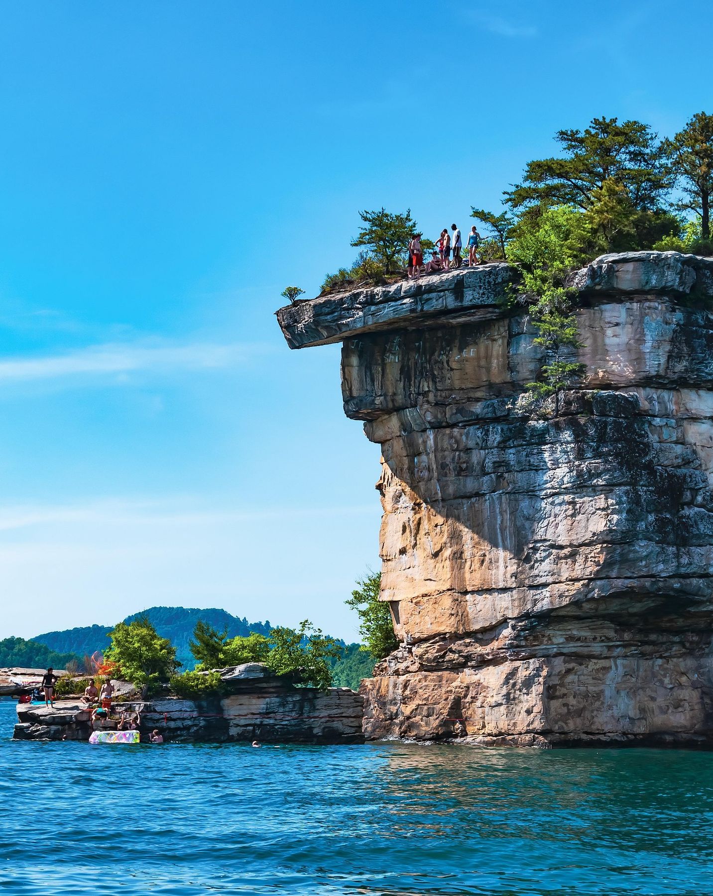 Cliffs above Summersville Lake with boaters and swimmers below